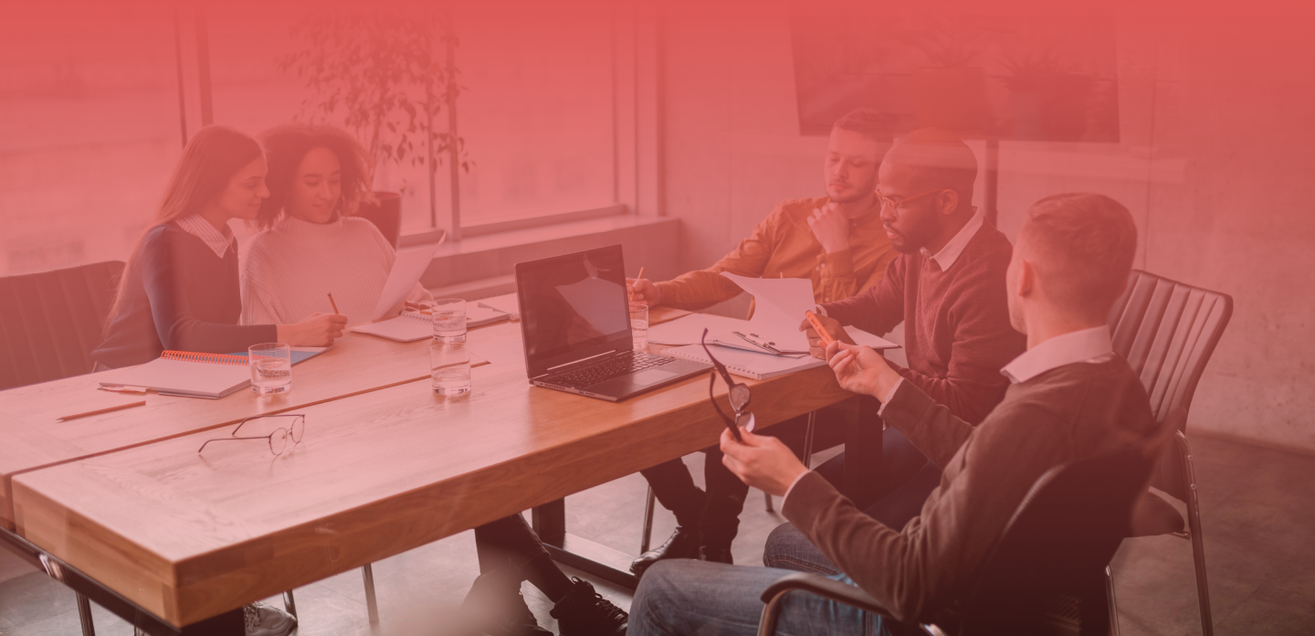 A group of coworkers, discussing business-related topic in a meeting room